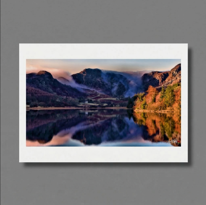 Stwlan Dam is etched into the harsh, snow-covered slopes of the Moelwyns. Long celebrated as a marvel of mid-century hydroelectric ingenuity and a solitary beacon for determined hikers, this remote alpine reservoir retains a deeply formidable, yet industrial and wild, charm. Its sweeping, rhythmic concrete arches and stark, man-made symmetry offer a rigid, resolute contrast to the chaotic, jagged ridges and sheer, snow-filled gullies of the mountains towering immediately above.
