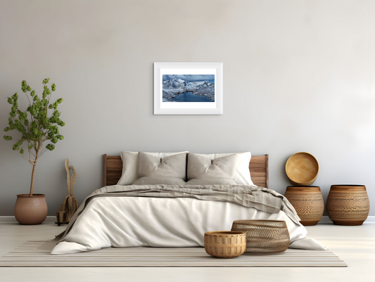 Bedroom with wooden headboard, white bedding, and decorative items on a neutral color scheme.